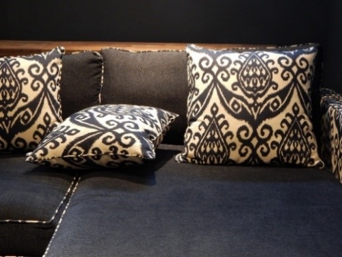 Des coussins au design noir et blanc posés sur un canapé noir
