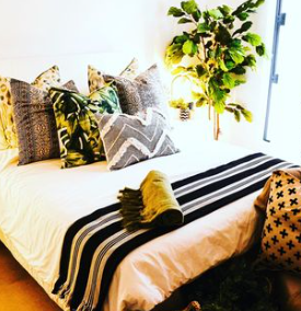 Des coussins de divers designs posés sur un lit